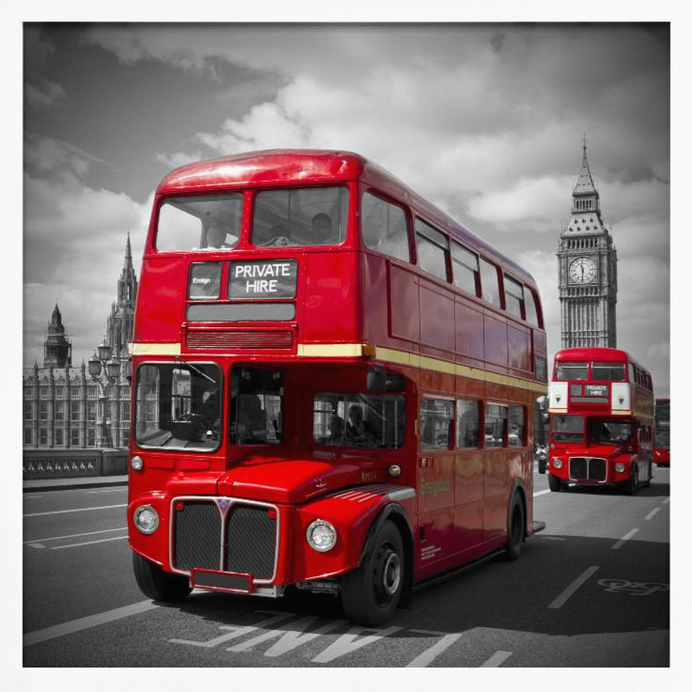 A framed, selective color photograph of a bright red, vintage double-decker bus on a bridge in London. The background, including the Big Ben clock tower, is in black and white, making the red bus stand out. Artwork