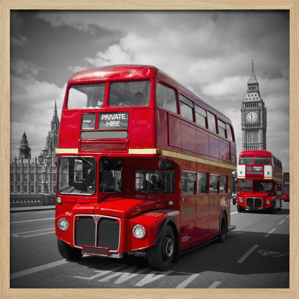 A framed, selective color photograph of a bright red, vintage double-decker bus on a bridge in London. The background, including the Big Ben clock tower, is in black and white, making the red bus stand out. Artwork