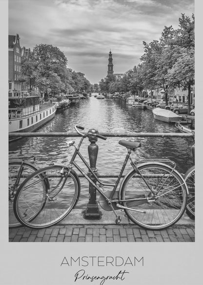 A black and white poster of the Prinsengracht canal in Amsterdam. A bicycle is parked on a bridge in the foreground, overlooking the canal lined with houseboats, trees, and traditional Dutch buildings. The Westerkerk church tower is visible in the distance. The poster has a white border with the words 'AMSTERDAM', 'Prinsengracht', and 'NEDERLAND' at the bottom. Poster