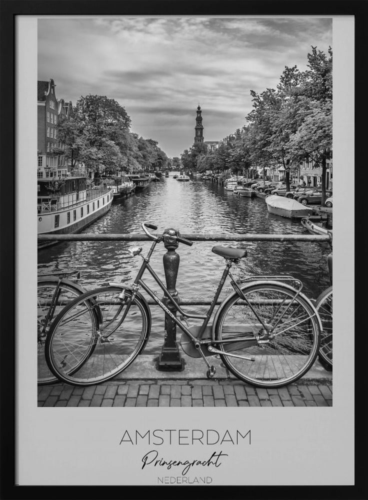 A black and white poster of the Prinsengracht canal in Amsterdam. A bicycle is parked on a bridge in the foreground, overlooking the canal lined with houseboats, trees, and traditional Dutch buildings. The Westerkerk church tower is visible in the distance. The poster has a white border with the words 'AMSTERDAM', 'Prinsengracht', and 'NEDERLAND' at the bottom. Poster