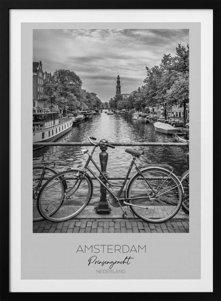 A black and white poster of the Prinsengracht canal in Amsterdam. A bicycle is parked on a bridge in the foreground, overlooking the canal lined with houseboats, trees, and traditional Dutch buildings. The Westerkerk church tower is visible in the distance. The poster has a white border with the words 'AMSTERDAM', 'Prinsengracht', and 'NEDERLAND' at the bottom. Poster