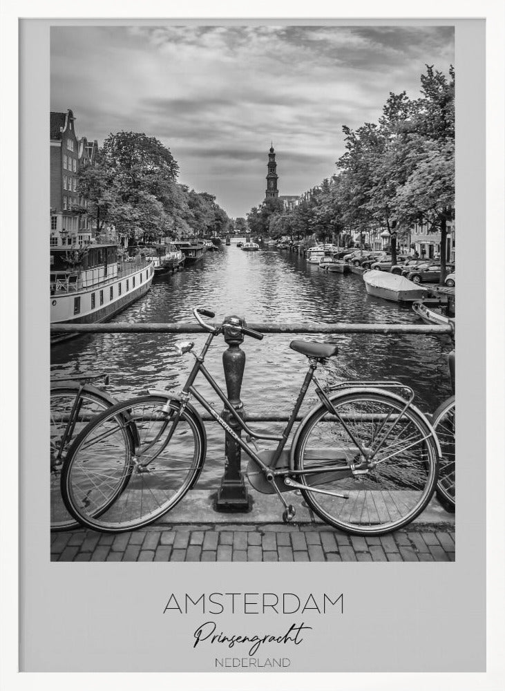 A black and white poster of the Prinsengracht canal in Amsterdam. A bicycle is parked on a bridge in the foreground, overlooking the canal lined with houseboats, trees, and traditional Dutch buildings. The Westerkerk church tower is visible in the distance. The poster has a white border with the words 'AMSTERDAM', 'Prinsengracht', and 'NEDERLAND' at the bottom. Poster