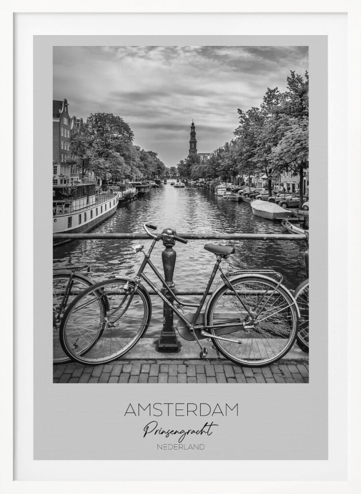 A black and white poster of the Prinsengracht canal in Amsterdam. A bicycle is parked on a bridge in the foreground, overlooking the canal lined with houseboats, trees, and traditional Dutch buildings. The Westerkerk church tower is visible in the distance. The poster has a white border with the words 'AMSTERDAM', 'Prinsengracht', and 'NEDERLAND' at the bottom. Poster