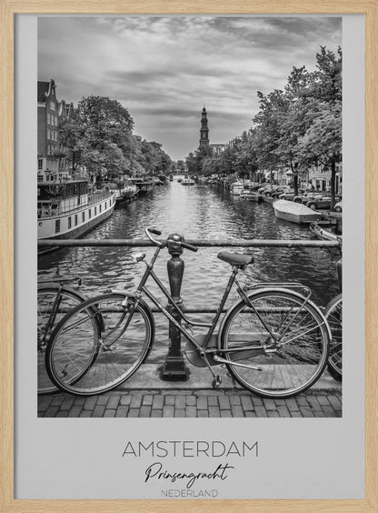 A black and white poster of the Prinsengracht canal in Amsterdam. A bicycle is parked on a bridge in the foreground, overlooking the canal lined with houseboats, trees, and traditional Dutch buildings. The Westerkerk church tower is visible in the distance. The poster has a white border with the words 'AMSTERDAM', 'Prinsengracht', and 'NEDERLAND' at the bottom. Poster