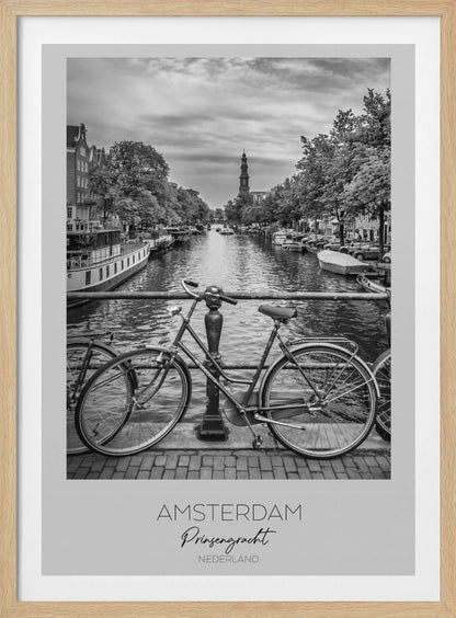 A black and white poster of the Prinsengracht canal in Amsterdam. A bicycle is parked on a bridge in the foreground, overlooking the canal lined with houseboats, trees, and traditional Dutch buildings. The Westerkerk church tower is visible in the distance. The poster has a white border with the words 'AMSTERDAM', 'Prinsengracht', and 'NEDERLAND' at the bottom. Poster