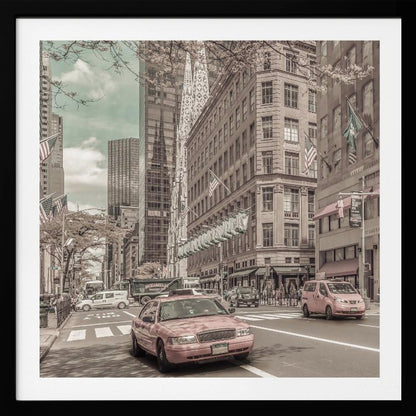 A framed photograph of a busy New York City street with a vintage, sepia-toned filter. Two cars, one in the foreground and one in the midground, are selectively colored a dusty pink, contrasting with the muted tones of the surrounding skyscrapers, American flags, and pedestrians. The sky is a pale teal color. Poster