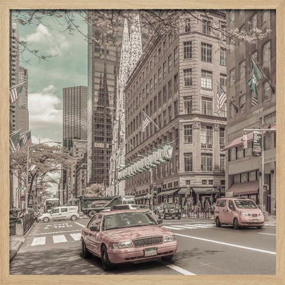 A framed photograph of a busy New York City street with a vintage, sepia-toned filter. Two cars, one in the foreground and one in the midground, are selectively colored a dusty pink, contrasting with the muted tones of the surrounding skyscrapers, American flags, and pedestrians. The sky is a pale teal color. Poster