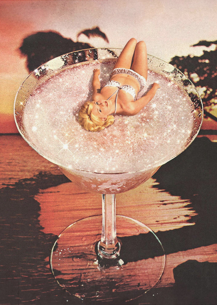 A surreal collage featuring a blonde woman in a white bikini lounging in a giant cocktail glass filled with a sparkling pink liquid, set against a warm sunset over the ocean. Print