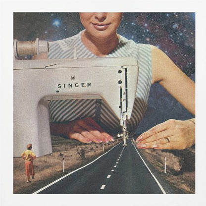 A surreal collage in a light wood frame featuring a giant woman in a striped dress using a vintage Singer sewing machine to stitch the white dashed lines onto an empty road that stretches into the distance. The background behind the woman is a starry galaxy, and a small woman in vintage clothing stands on the side of the road looking on. Print
