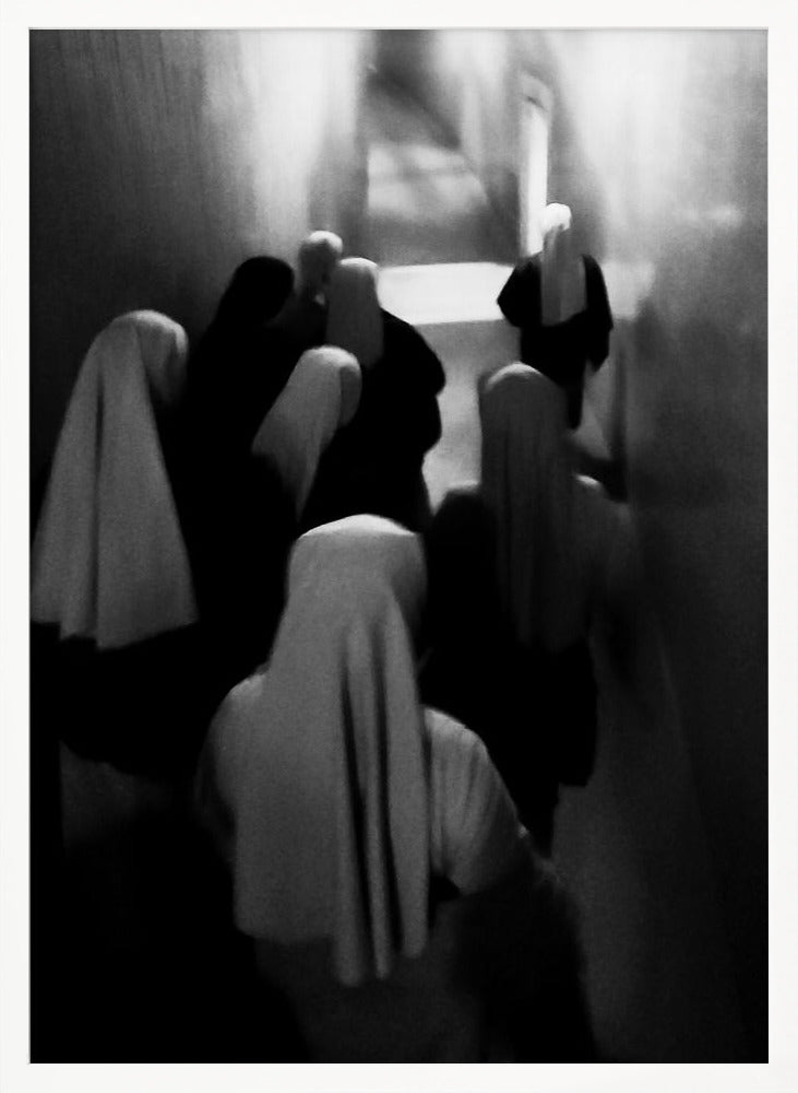 A mysterious black and white photograph captures a group of robed figures, possibly nuns, from above as they walk down a dark, narrow corridor. The image is blurred, creating a ghostly, ethereal atmosphere as the figures' white head coverings stand out against the deep shadows. Artwork