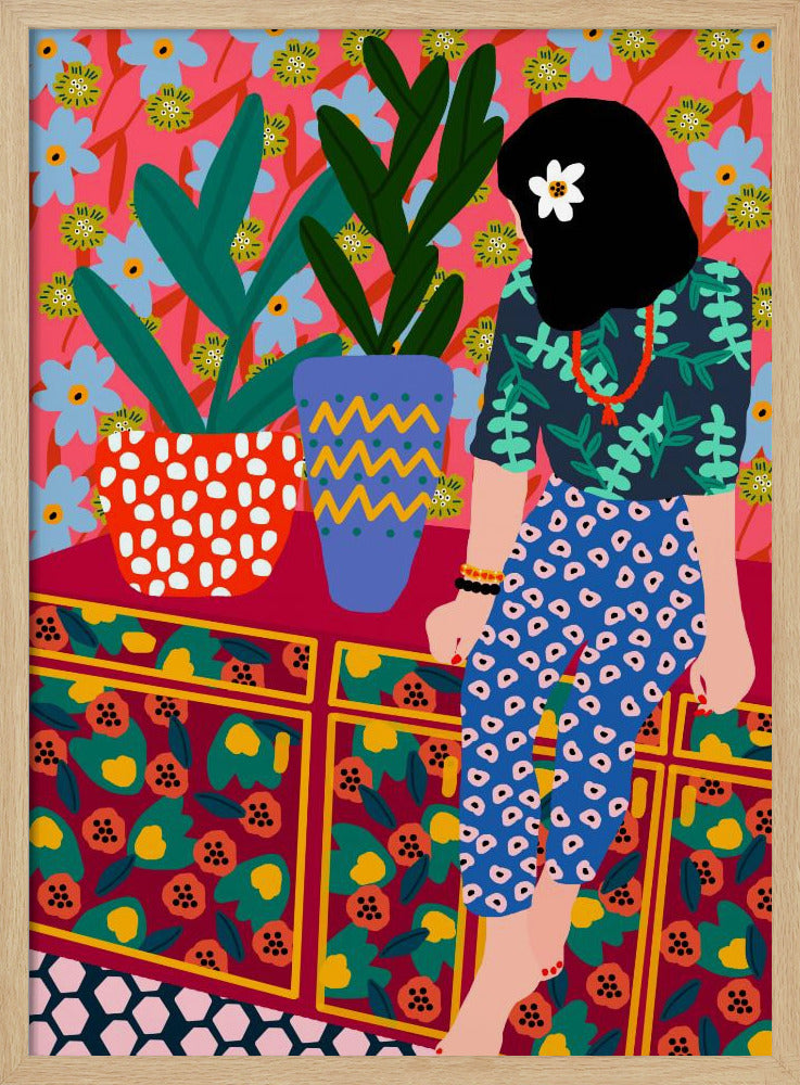 A colorful, maximalist illustration of a woman with black hair and a flower, sitting on a patterned cabinet. She wears a dark blue shirt with green leaves and blue pants with white circles. Next to her are two potted plants in brightly patterned pots, set against a pink and blue floral wallpaper. Poster