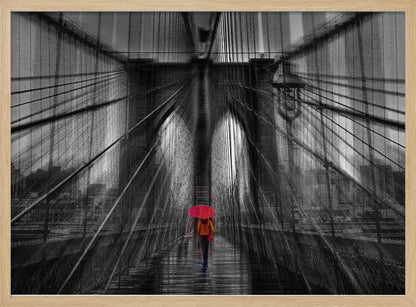 A motion-blurred, black and white photo of the Brooklyn Bridge with a person holding a bright red umbrella walking down the center. The selective color makes the red umbrella the focal point against the dramatic, almost abstract lines of the bridge's cables and arches on a wet, reflective walkway. The image is presented in a silver frame. Wall Art