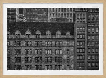 A dense, black and white photograph of various city buildings packed closely together. The image highlights the contrasting architectural styles, from an older stone building with a dark roof in the foreground to taller brick and modern glass buildings in the background, creating a geometric pattern of windows and textures. Decor