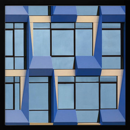 A framed abstract architectural photograph showing a repeating pattern of a modern building's facade. The image features geometric, three-dimensional blue elements surrounding light blue windows with black frames, all set against horizontal cream-colored bands. The entire piece is presented within a light wood frame. Print