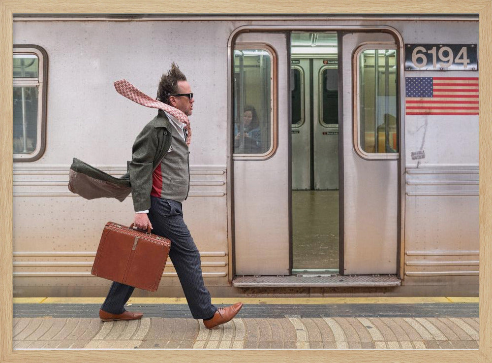 A stylish man with windblown hair and a flying scarf walks briskly along a subway platform, carrying a brown briefcase next to a silver train. Artwork