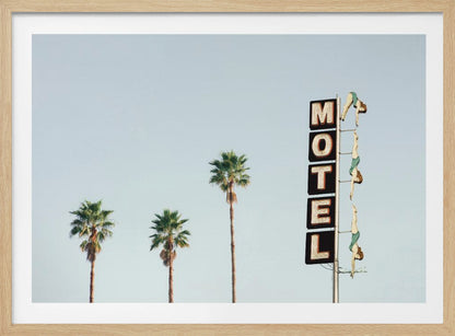 A minimalist photograph featuring three tall palm trees and a vertical black and white 'MOTEL' sign against a pale blue sky. Affixed to the sign's pole are several figures of women in green swimsuits, posed as if diving in a synchronized formation. Poster