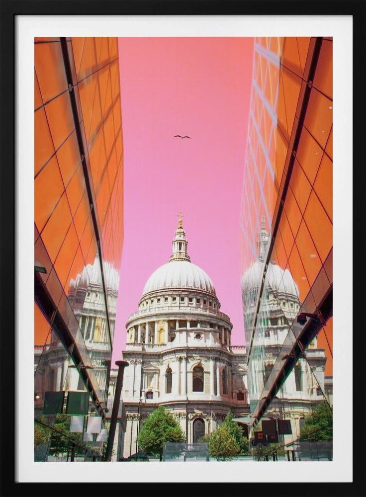 A low-angle, surrealist photograph of a classic white dome cathedral, framed perfectly between two modern orange glass buildings. The cathedral's reflection is visible on the buildings' surfaces against a vibrant, solid pink sky with a lone bird in flight. Poster