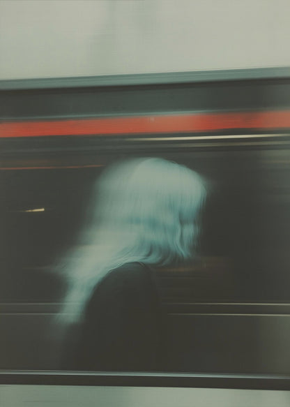 An abstract photograph with motion blur, featuring the ghostly silhouette of a person's head and shoulders in pale blue. The dark background is streaked with horizontal lines of red and white light, suggesting the speed of a passing train or subway. Wall Art