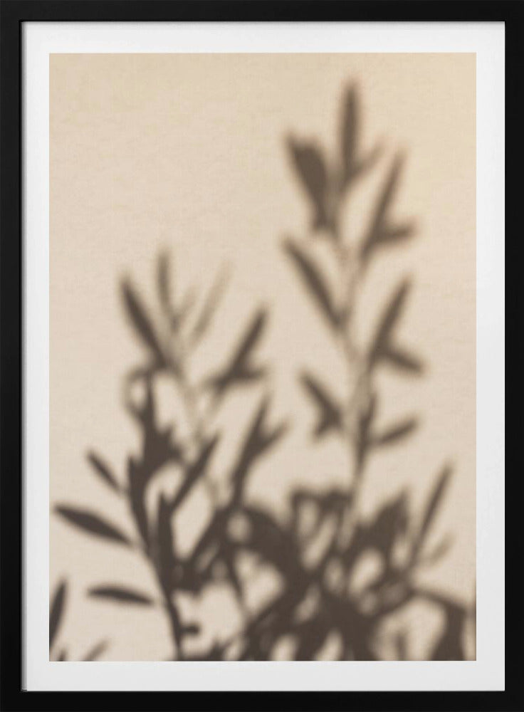 A framed photograph featuring the soft, out-of-focus shadow of a leafy plant projected onto a warm, beige-colored wall. The image has a minimalist and tranquil aesthetic, focusing on the interplay of light and shadow. Wall Art