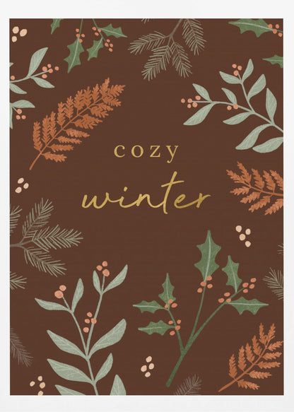 A warm, illustrative poster with a dark brown background featuring the words 'cozy winter' in gold script at the center. The text is framed by a wreath of winter botanicals, including holly, pine needles, and ferns in shades of green and burnt orange. Print