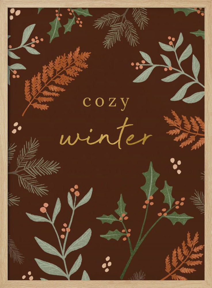 A warm, illustrative poster with a dark brown background featuring the words 'cozy winter' in gold script at the center. The text is framed by a wreath of winter botanicals, including holly, pine needles, and ferns in shades of green and burnt orange. Print