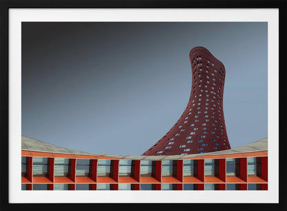 A modern architectural photograph showing a curved, maroon skyscraper twisting towards the sky against a gradient grey background. A lower, orange, grid-like building curves along the bottom of the frame. The entire scene is enclosed in a silver frame. Poster