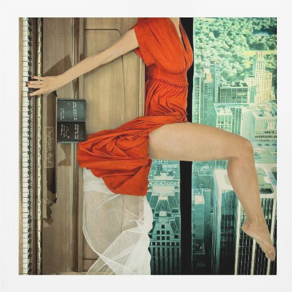 A surrealist collage artwork in a light wood frame, featuring the fragmented body of a woman in a vibrant orange dress. Her arm reaches to touch the keys of an upright piano on the left, while her legs are positioned as if sitting on a ledge overlooking a teal-toned cityscape on the right. Artwork