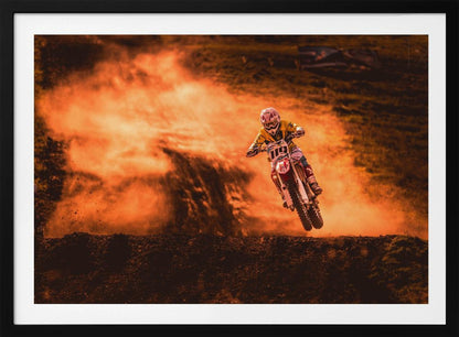 An action-packed photo of a motocross rider in mid-air, jumping their dirt bike over a mound of earth. A large cloud of orange dust billows behind them, creating a dramatic and fiery background. Wall Art