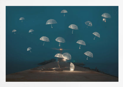 A surreal night scene with a person lying on a pier next to a glowing, transparent umbrella, while numerous other glowing umbrellas float like jellyfish in the dark blue sky above the sea, with a distant lighthouse in the background. Poster