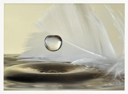A high-speed macro photograph captures a perfectly spherical water droplet suspended in mid-air above a ripple on the water's surface. A soft white feather lies in the background, creating a serene and delicate composition with a neutral color palette, all enclosed in a brushed silver frame. Wall Art