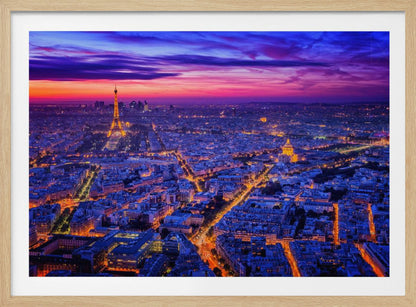 An aerial panoramic view of Paris at dusk, with the cityscape illuminated in cool blue and warm yellow lights. The Eiffel Tower is prominently lit on the left under a dramatic sunset sky transitioning from orange and pink to deep purple. Poster