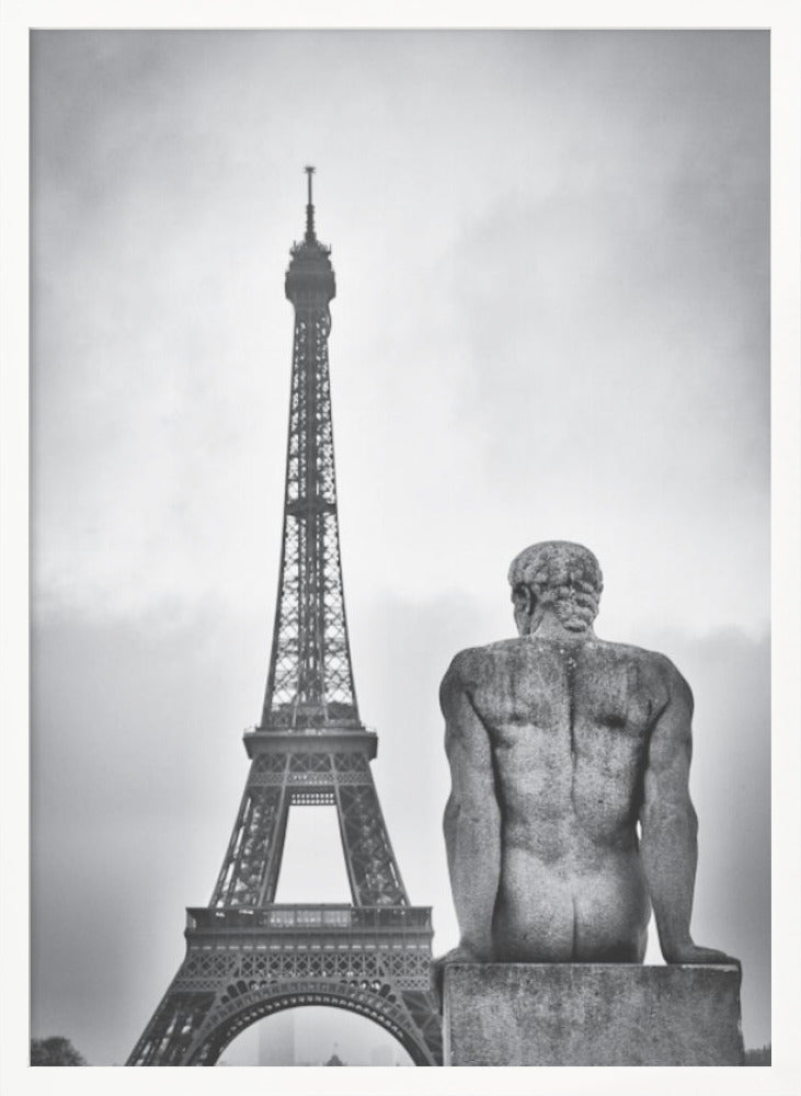 A black and white photograph capturing a contemplative scene in Paris, with the back of a seated, muscular male stone statue in the foreground looking towards the iconic Eiffel Tower which stands tall against a cloudy sky. Print
