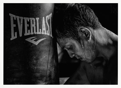 A dramatic black and white close-up photograph of an exhausted boxer resting his head against a heavy Everlast punching bag, with sweat dripping down his face and neck. Poster