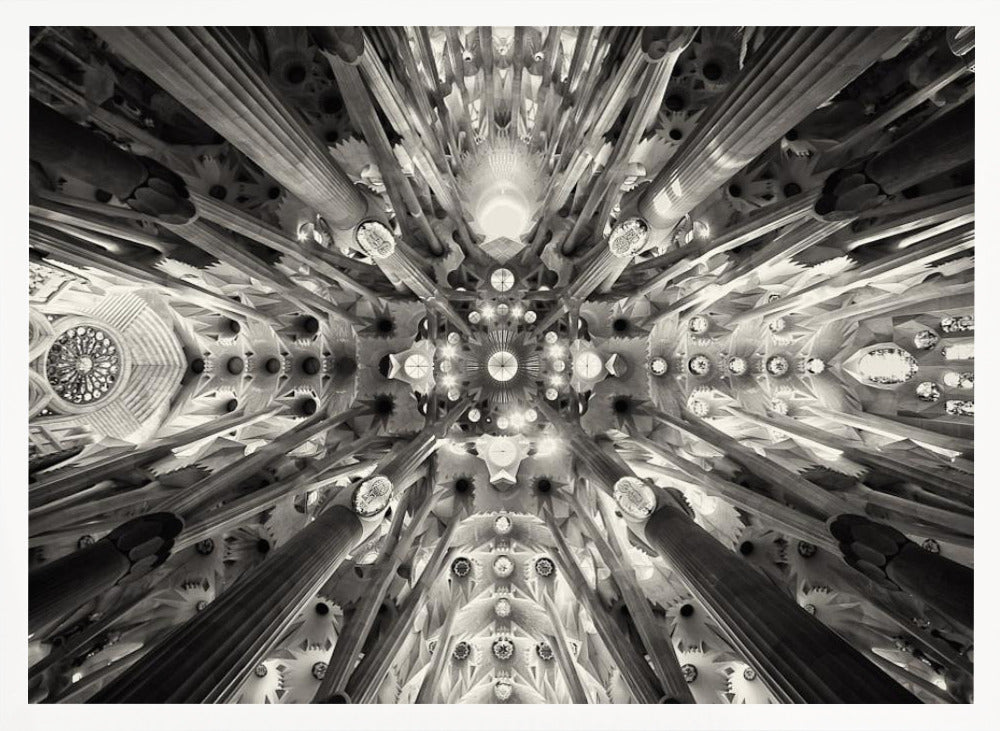 A framed black and white photograph captures the breathtaking, symmetrical ceiling of Gaudí's Sagrada Familia basilica, viewed directly from below. The massive columns rise and branch out like a forest canopy, creating a complex and mesmerizing architectural pattern of vaults, ribs, and skylights. Artwork