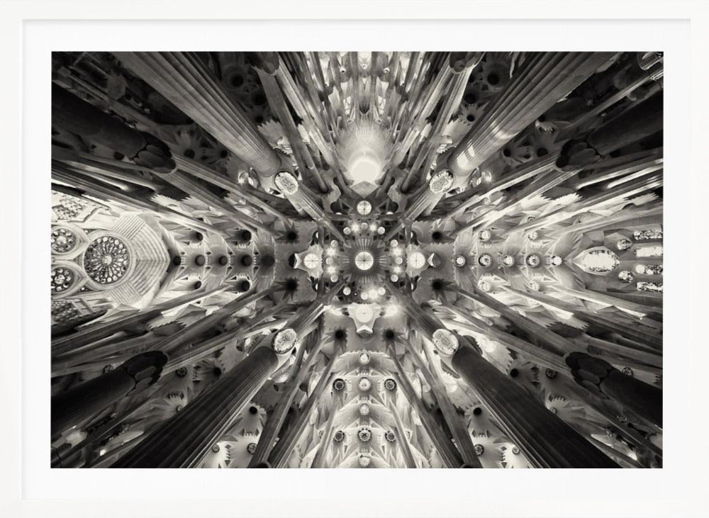 A framed black and white photograph captures the breathtaking, symmetrical ceiling of Gaudí's Sagrada Familia basilica, viewed directly from below. The massive columns rise and branch out like a forest canopy, creating a complex and mesmerizing architectural pattern of vaults, ribs, and skylights. Artwork