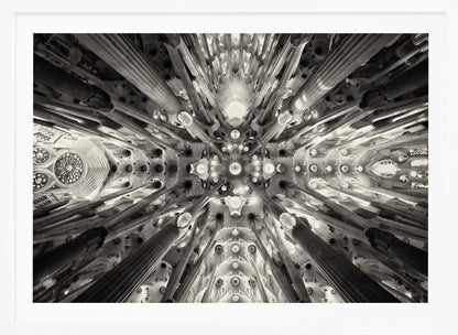 A framed black and white photograph captures the breathtaking, symmetrical ceiling of Gaudí's Sagrada Familia basilica, viewed directly from below. The massive columns rise and branch out like a forest canopy, creating a complex and mesmerizing architectural pattern of vaults, ribs, and skylights. Artwork