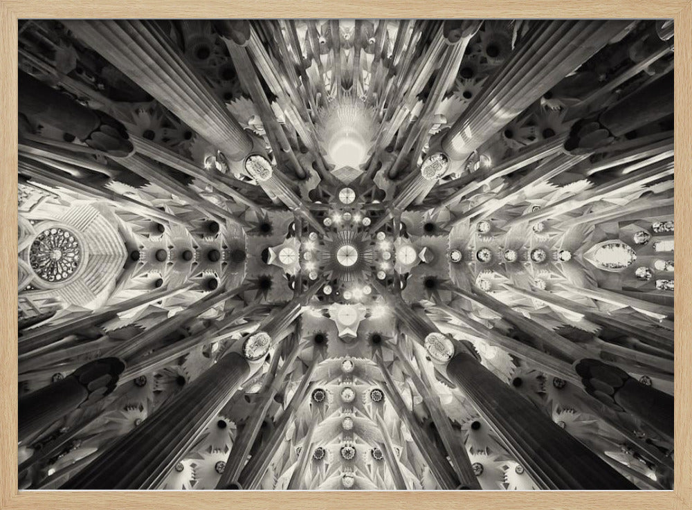 A framed black and white photograph captures the breathtaking, symmetrical ceiling of Gaudí's Sagrada Familia basilica, viewed directly from below. The massive columns rise and branch out like a forest canopy, creating a complex and mesmerizing architectural pattern of vaults, ribs, and skylights. Artwork