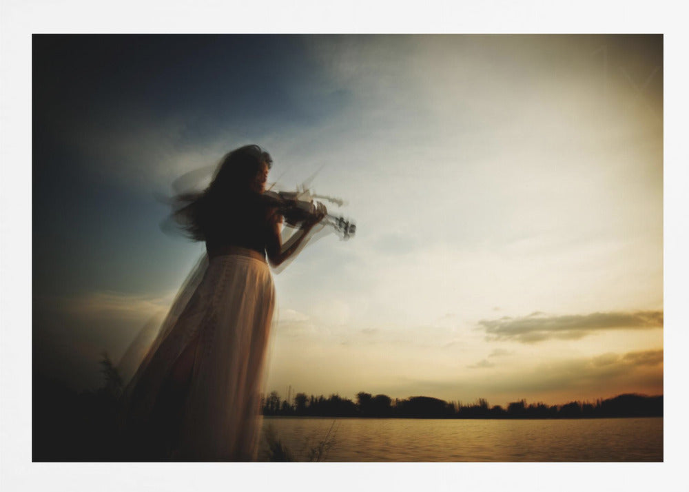 An artistic, framed photograph with motion blur capturing the silhouette of a woman in a long flowing skirt playing the violin by a lake against a dramatic sunset sky. Poster