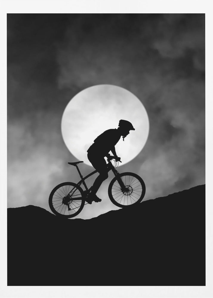 A dramatic black and white silhouette of a mountain biker riding uphill against the backdrop of a large, full moon in a cloudy night sky. Decor