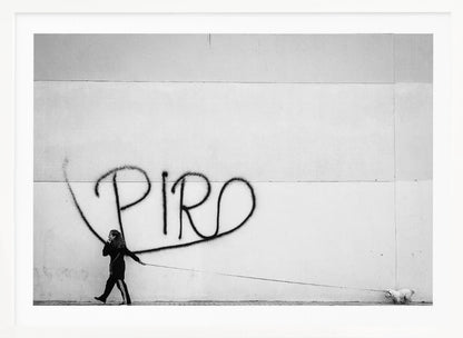A minimalist black and white photograph of a woman dressed in black walking a small, fluffy white dog on a long leash. They are walking along a sidewalk in front of a large, pale wall with the word 'PIRO' written in black spray paint graffiti. The entire image is enclosed in a light grey frame. Poster