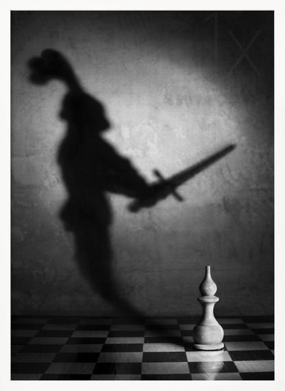 A black and white conceptual photograph of a single white chess piece on a checkerboard, casting a large, ominous shadow of a medieval knight holding a sword against a textured wall. Print
