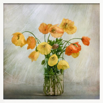 A soft-focus still life photograph of a bouquet of yellow and orange poppies in a clear glass jar, set against a delicate, light green textured background, all enclosed in a light wood frame. Print