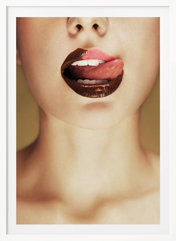 A close-up photograph of a woman's mouth with two-toned lipstick. The lips are mostly covered in glossy dark brown, with the upper right section in light pink. Her tongue is out, licking the pink part of her lip, revealing her white teeth. Print