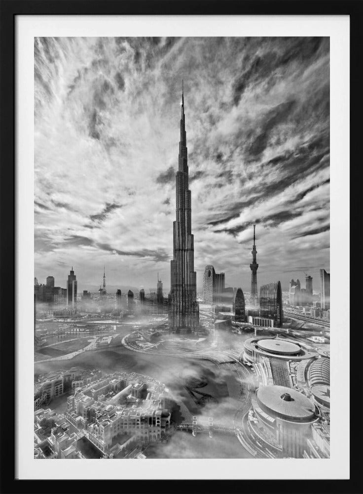 A dramatic black and white high-angle photograph of the Burj Khalifa dominating the Dubai cityscape, with swirling clouds above and a light mist surrounding the buildings below, all enclosed in a black frame. Poster