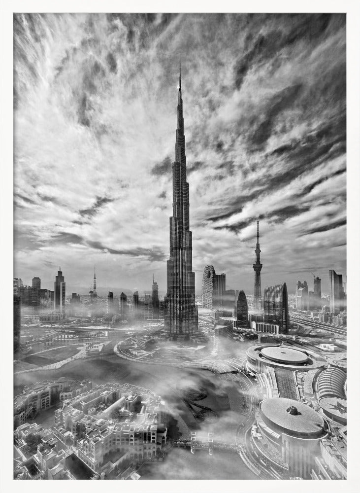 A dramatic black and white high-angle photograph of the Burj Khalifa dominating the Dubai cityscape, with swirling clouds above and a light mist surrounding the buildings below, all enclosed in a black frame. Poster