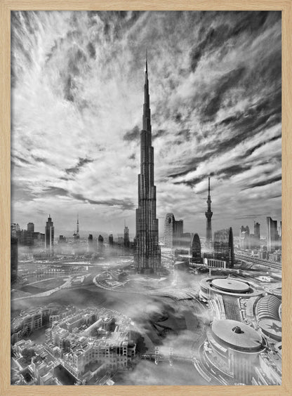 A dramatic black and white high-angle photograph of the Burj Khalifa dominating the Dubai cityscape, with swirling clouds above and a light mist surrounding the buildings below, all enclosed in a black frame. Poster