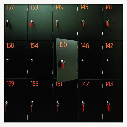 A head-on shot of a grid of black lockers inside a light wood frame. Each locker has a bright orange number and a key with a red tag. Locker number 150 is open, creating a focal point in the otherwise uniform pattern. Wall Art