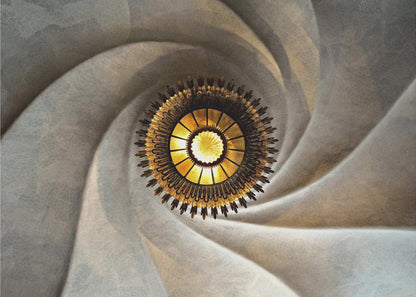 A low-angle, centered photograph looking up at an ornate, golden sunburst chandelier hanging from the vortex of a swirling, textured cream-colored ceiling, enclosed in a silver frame. Poster