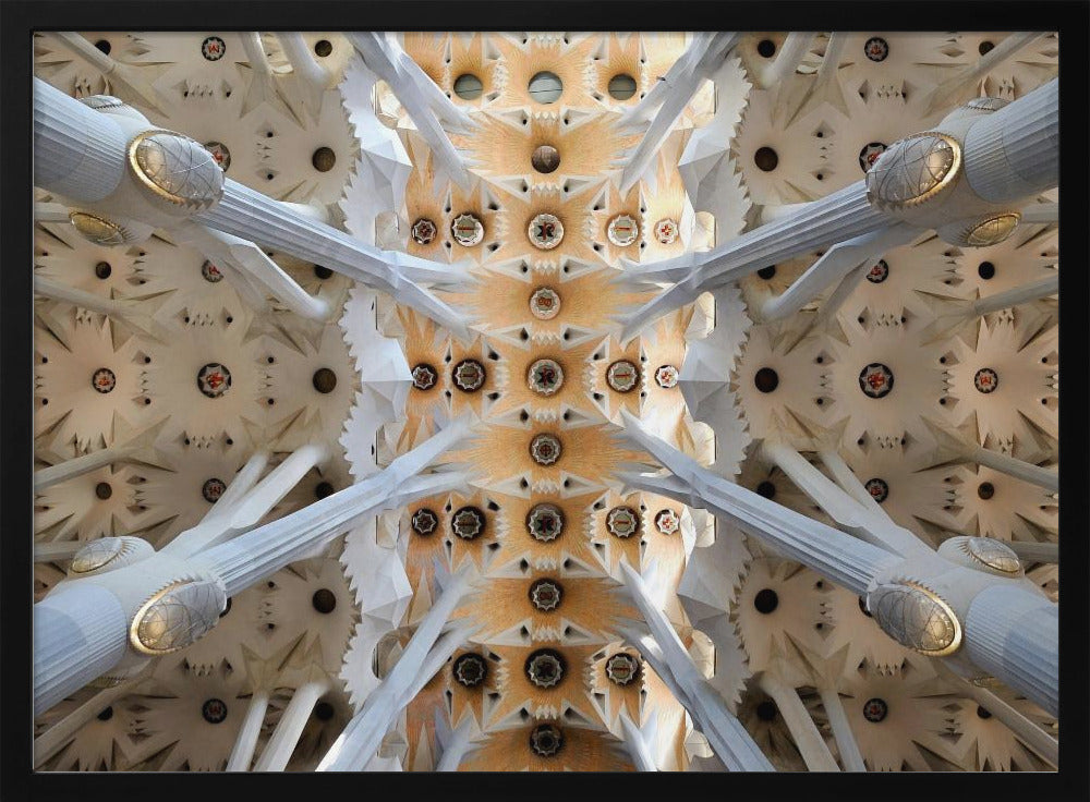 A symmetrical photograph looking directly up at the ornate, geometric ceiling of the Sagrada Familia. White, tree-like columns branch out to support the intricate vaulted ceiling, which is detailed with warm orange and gold starburst patterns. Decor