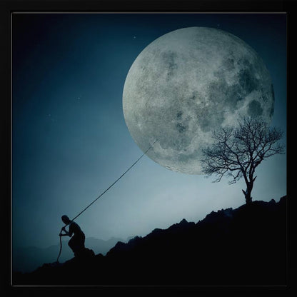 A surreal, framed artwork depicting a silhouette of a person on a dark, rocky hill at night, pulling a rope attached to a massive, detailed full moon, seemingly trying to pull it from the dark blue, star-dusted sky. A bare, silhouetted tree stands on the same hill. Artwork